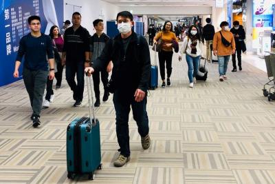 homem caminha por saguão de aeroporto