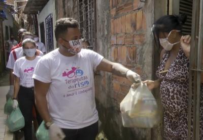 voluntários entregam cestas básicas