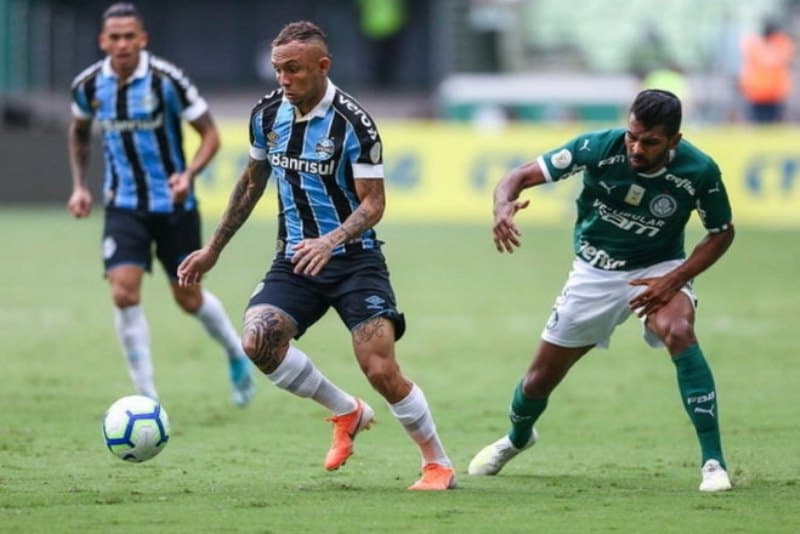 jogadores de futebol disputam bola