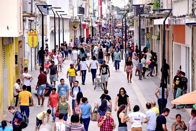 pessoas andam por rua