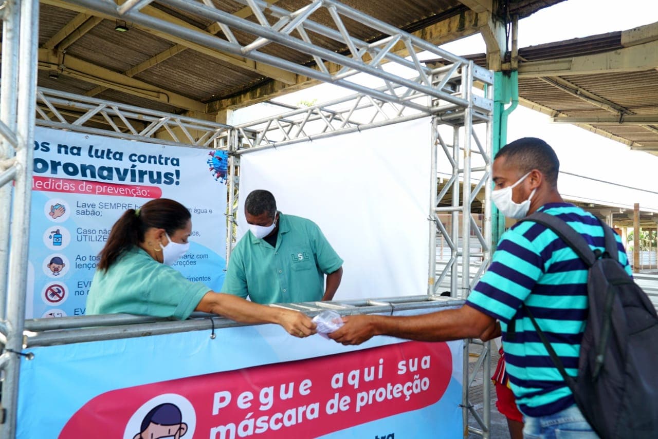 agente de saúde entrega máscara descartável