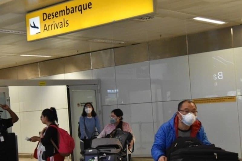 homem caminha por saguão de aeroporto