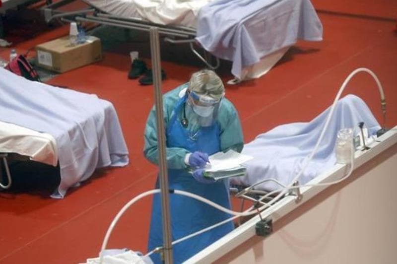 médico ao lado de leito