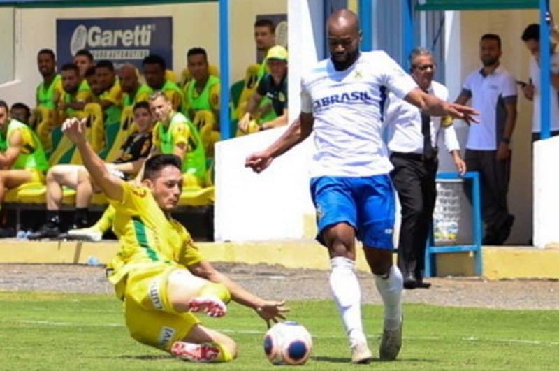 jogadores de futebol disputam bola