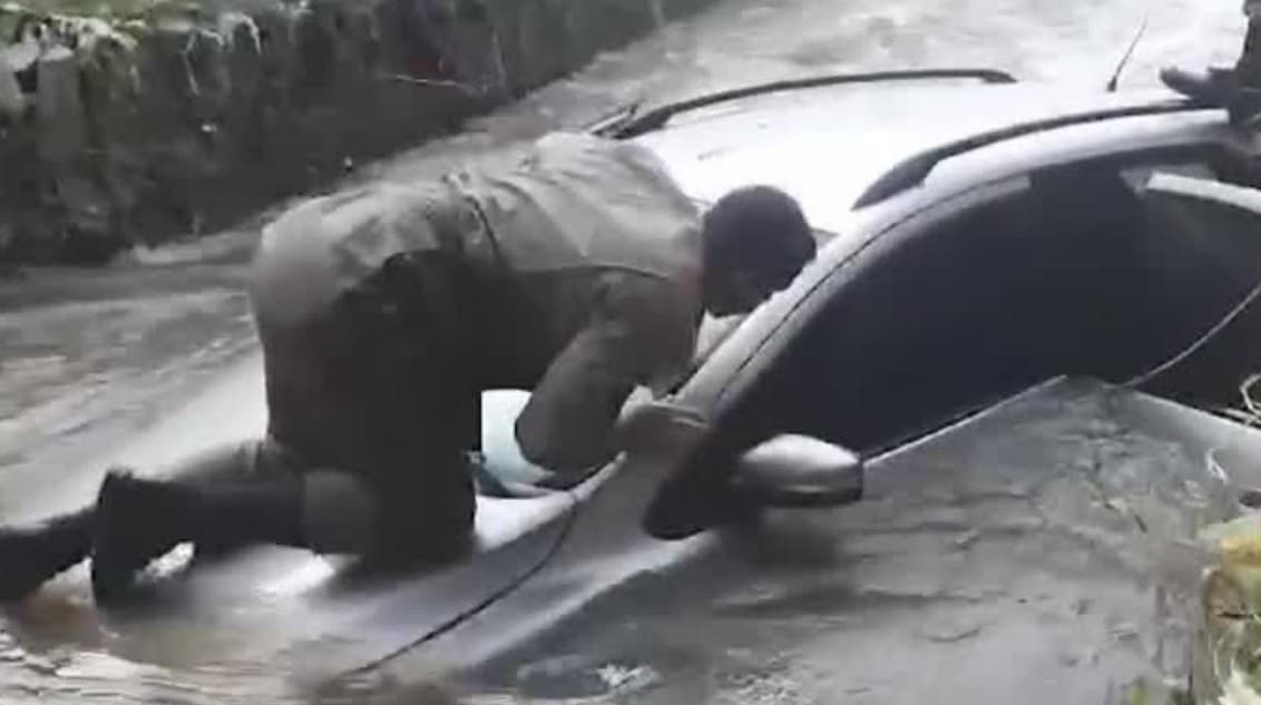 Policiais resgatam ocupantes de carro que caiu em córrego durante chuva